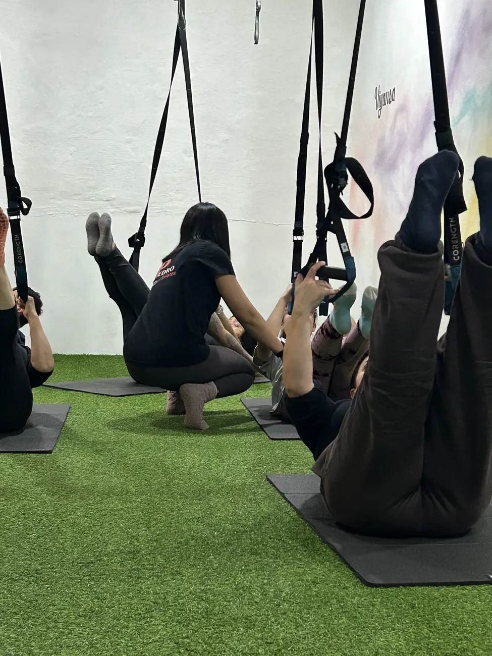 Clase grupal de TRX con instructor guiando ejercicios